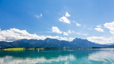 Yelkenli tekneleri, dağ manzarası ve mavi gökyüzü olan Panorama Gölü  