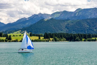Yelkenli tekneleri, dağ manzarası ve mavi gökyüzü olan Panorama Gölü  