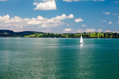 Yelkenli tekneleri, dağ manzarası ve mavi gökyüzü olan Panorama Gölü  