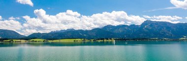 Yelkenli tekneleri, dağ manzarası ve mavi gökyüzü olan Panorama Gölü  