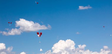 Gökyüzünde uçan kırmızı ve beyaz balonlar