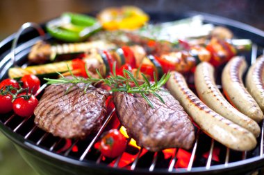 barbekü üzerinde kömürler üzerinde sebze ile lezzetli biftek ve sosis yakın çekim görünümü  
