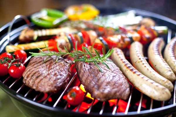 バーベキューで石炭の上に野菜とおいしいステーキやソーセージのクローズアップビュー — ストック写真
