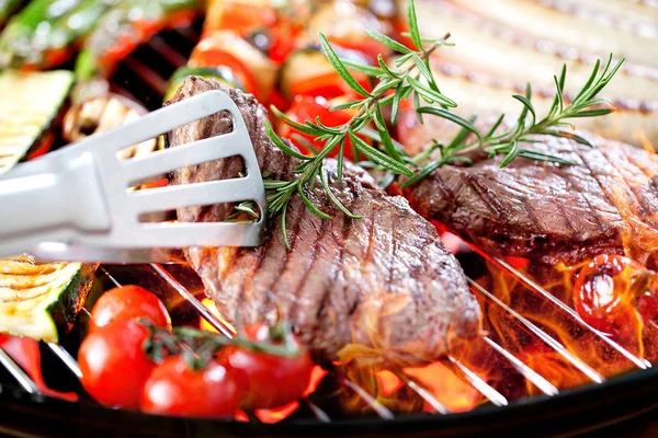 Vista Perto Pinças Bifes Com Alecrim Salsichas Tomates Cozinhando Grelha — Fotografia de Stock