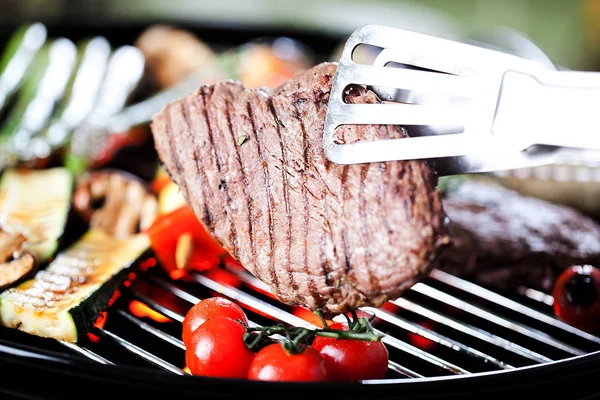 Vista Close Pinças Com Bife Legumes Cozinhar Grelha — Fotografia de Stock