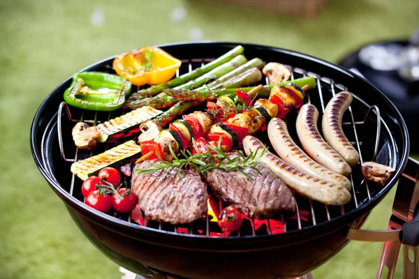바비큐에 야채와 다양한 맛있는 고기와 소시지의 클로즈업 — 스톡 사진