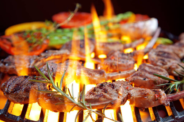 close-up view of delicious meat with rosemary, asparagus and peppers cooking on grill 