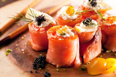 krem peynir, dereotu ve havyar ile lezzetli somon rulo yakın çekim görünümü, ahşap tahta üzerinde çubukları