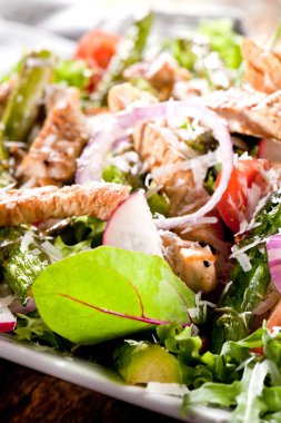 Croutons, kiraz domates ve koyu rustik masada tabakta ızgara tavuk ile Sezar salatası