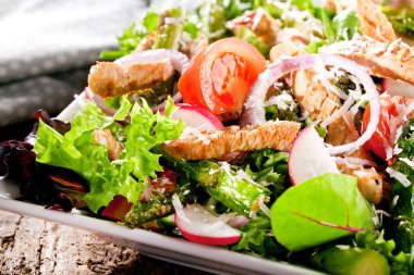 Croutons, kiraz domates ve koyu rustik masada tabakta ızgara tavuk ile Sezar salatası  