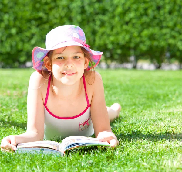 Cute Happy Dziecko Leżącego Trawie Książki Uśmiechnięty Aparacie Letni Dzień — Zdjęcie stockowe