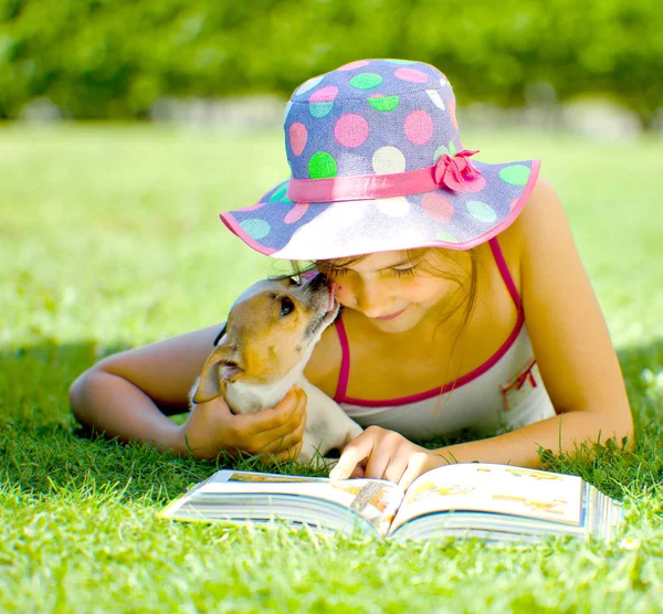 Очаровательный Улыбающийся Ребенок Лежит Траве Собакой Читает Книгу — стоковое фото