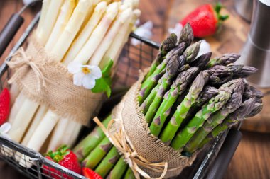 taze kuşkonmaz, çiçek ve olgun çilek sepeti ahşap masa üzerinde görmek
