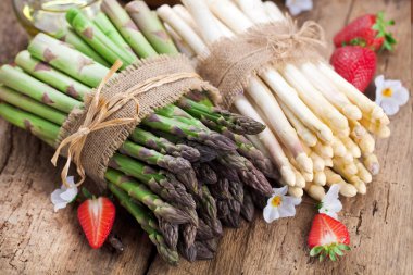 lezzetli yeşil ve beyaz kuşkonmaz yakından görmek, ahşap masa üzerinde olgun çilek