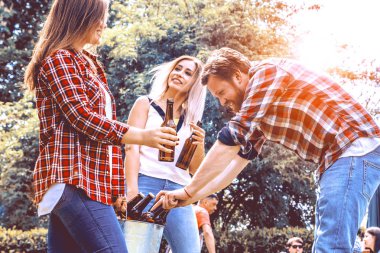 Mutlu genç arkadaşlar bira içip arka bahçede takılıyorlar.