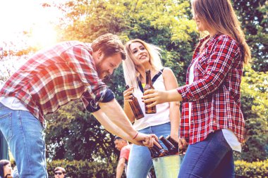 Mutlu genç arkadaşlar bira içip arka bahçede takılıyorlar.