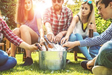 Neşeli genç arkadaşlar bira içip dışarıda takılıyorlar.