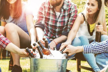 Neşeli genç arkadaşlar bira içip dışarıda takılıyorlar.