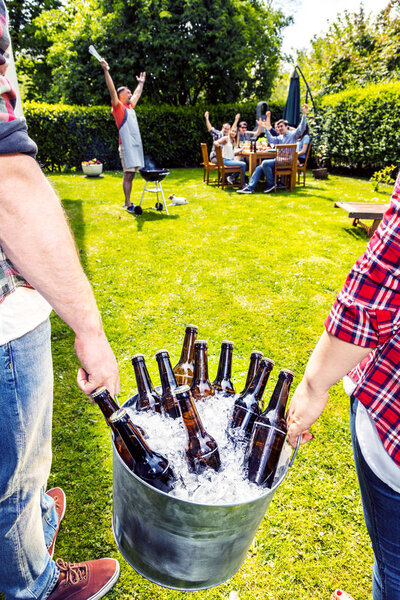 Diverse People Friends Hanging Out in Backyard and Carrying Bucket with Beer Bottles and Ice. Drinking Concept 