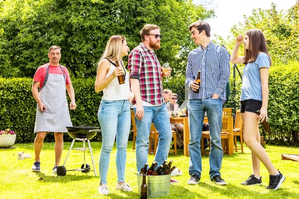 裏庭で遊ぶ多様な人たちとビールを飲む — ストック写真