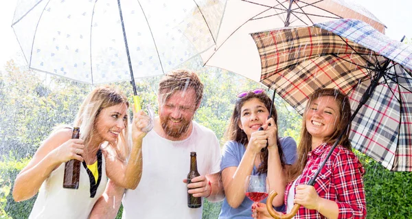友達屋外でぶら下がったり 傘を持ったり 裏庭でバーベキューをしたり — ストック写真