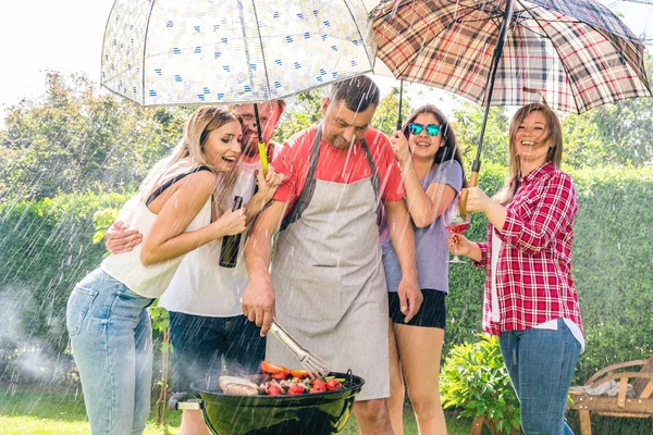 朋友们一起出去玩 在后院拿着雨伞 做着烧烤 — 图库照片