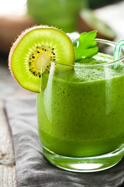 kivi smoothie, maydanoz ve ahşap masa üzerinde saman içme ile cam yakın çekim görünümü