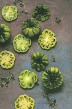 taze yeşil dilimlenmiş domates yaprakları ve otlar ile üstten görünüm gri yüzeyi   