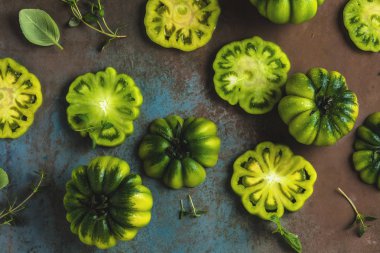 taze yeşil dilimlenmiş domates yaprakları ve otlar ile üstten görünüm gri yüzeyi   