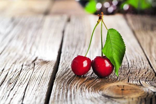Cherries with water drops on wooden table, macro background.