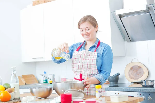 Sonriente Joven Delantal Añadiendo Aceite Mientras Cocina Cocina —  Fotos de Stock