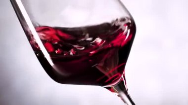 gri arka planda cam sallayarak kırmızı şarap yakın çekim görünümü