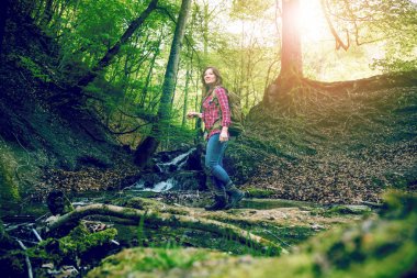 ormanda sırt çantası yürüyüş ile gülümseyen genç kadın düşük açılı görünümü 