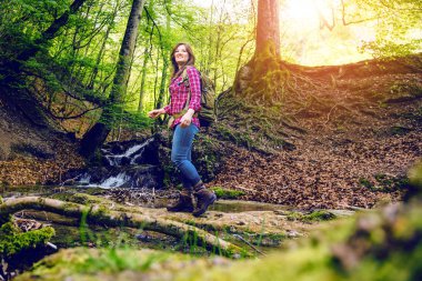 ormanda sırt çantası yürüyüş ile gülümseyen genç kadın düşük açılı görünümü  