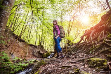 ormanda sırt çantası yürüyüş ile gülümseyen genç kadın düşük açılı görünümü 