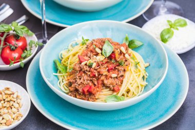 taze fesleğen ile süslenmiş lezzetli geleneksel İtalyan spagetti Bolognaise veya Bolognese yakın çekim görünümü