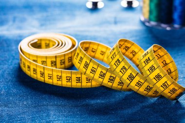 ölçüm bandı, dikiş aletleri ve denim kumaşın yakın çekim görünümü, dikiş arka planı  