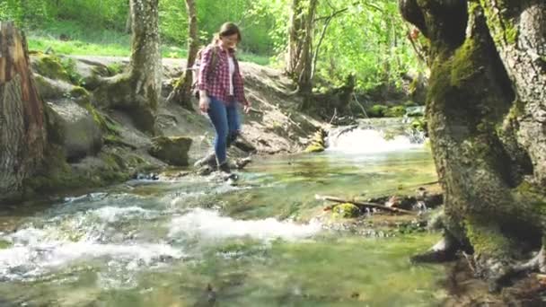 Улыбающаяся Молодая Женщина Рюкзаком Наступает Камни Быстрой Реке — стоковое видео