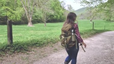 sırt çantası kırsal yolda çalışan mutlu genç kadının arka görünümü 