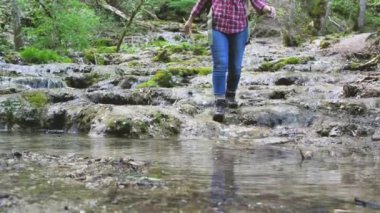 ormanda dere kayalar üzerinde yürüyen genç kadın yürüyüşçü kırpılmış atış 