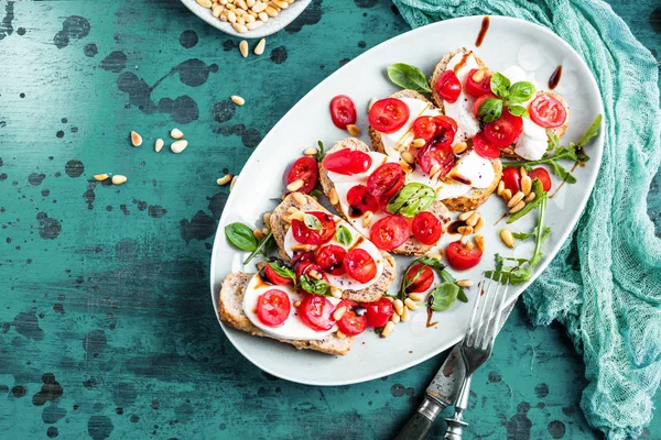 Närbild Läckra Bruschetta Med Körsbärstomater Rucola Och Mozzarella — Stockfoto