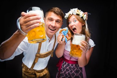 heyecanlı genç adam ve kadın bira bardak tutan ve kamera, oktoberfest kavramı gülüyor