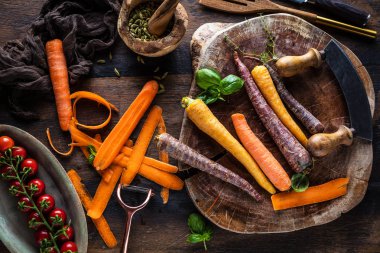 ahşap masada taze çiğ gökkuşağı havuç ve domates üst görünümü