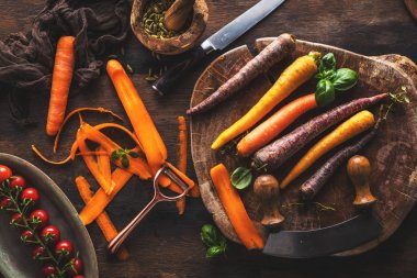 ahşap masada taze çiğ gökkuşağı havuç ve domates üst görünümü