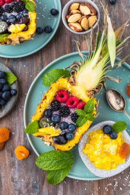 ahşap masada taze olgun ananas ve çilek ile lezzetli tatlı üst görünümü   