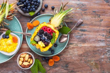 ahşap masada taze olgun ananas ve çilek ile lezzetli tatlı üst görünümü