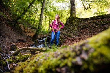 şelale yakın güzel ormanda sırt çantası yürüyüş ile genç kadın, düşük açı görünümü