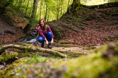 şelale yakın güzel ormanda sırt çantası yürüyüş ile genç kadın 
