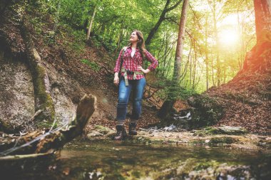 güzel ormanda sırt çantası ile güzel kız bir şelale yakın yürüyüş yaparken 