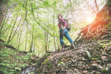 güzel ormanda sırt çantası ile gülümseyen genç kadının düşük açı görünümü 